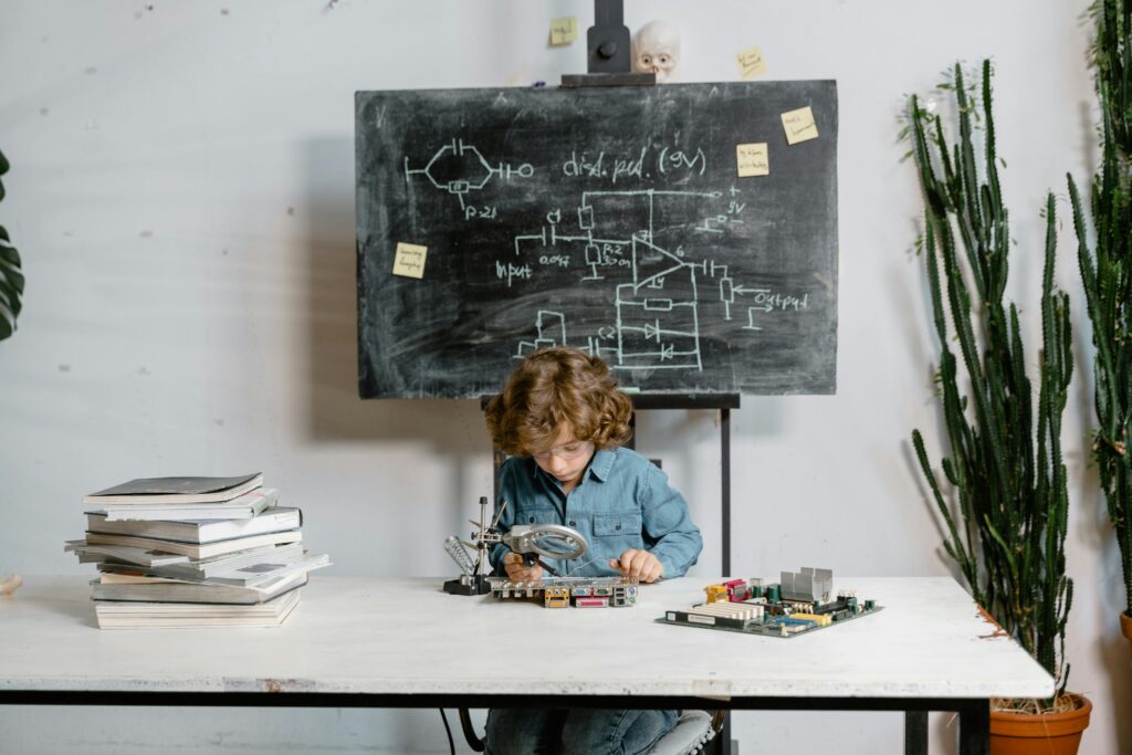 Young boy focused on soldering electronic circuits at a desk, learning technology.